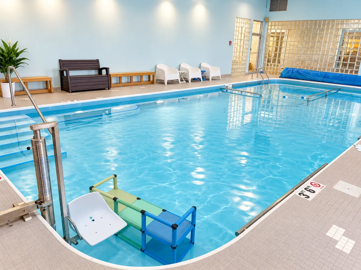 The warm indoor pool at Anchor Wellness Studio with handrails, steps and tall windows